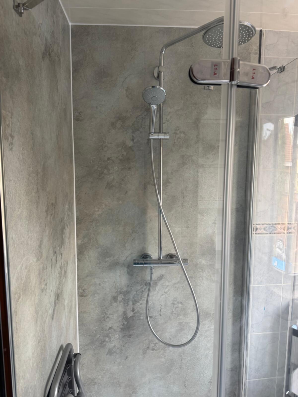 Douche met grijze betegeling en moderne douchekop