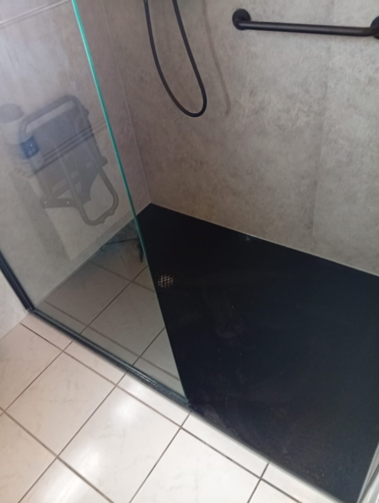 Douchecabine met glazen deur en zwarte basisplaat