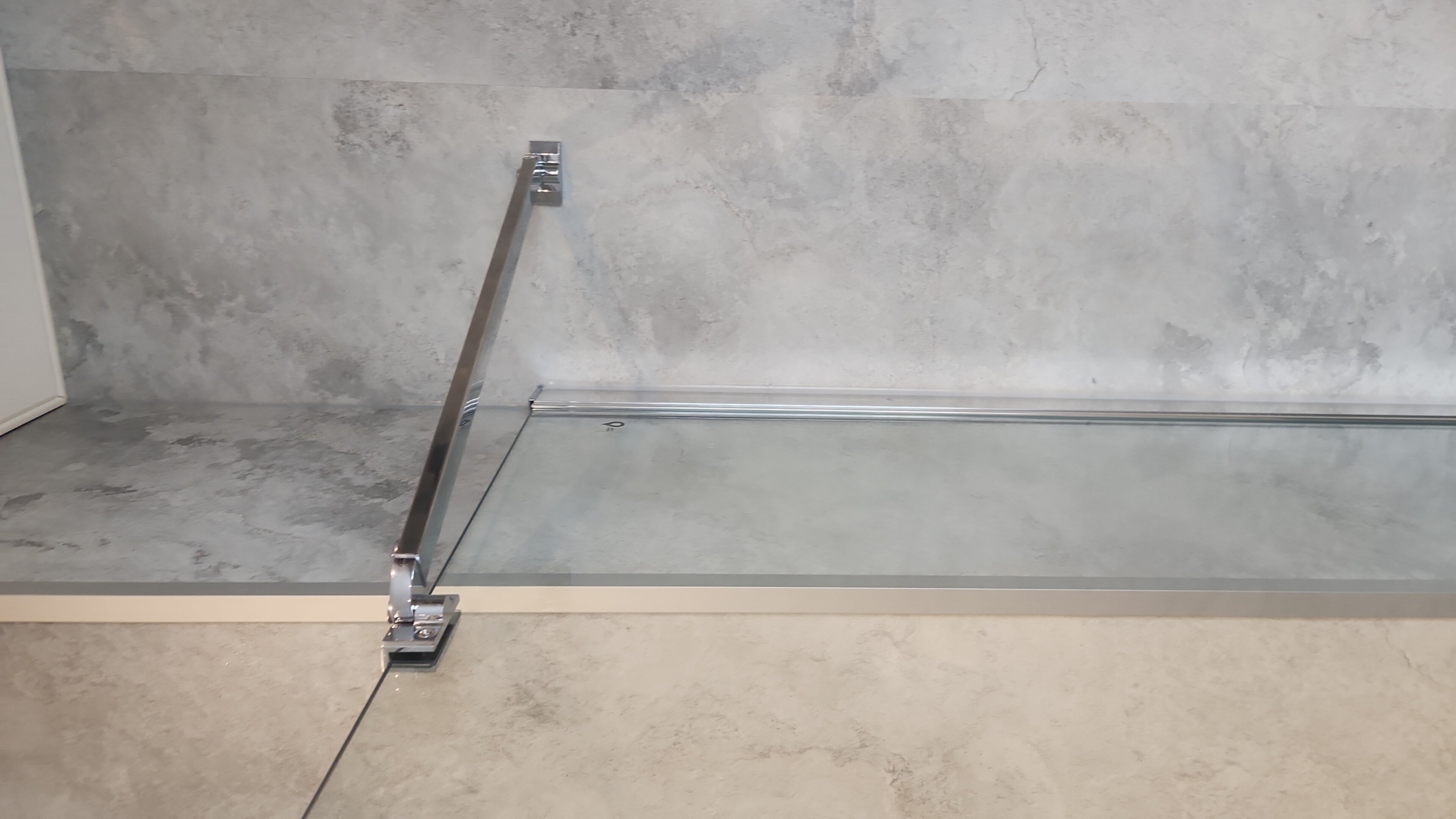 Douche met glazen deur en grijze betegeling