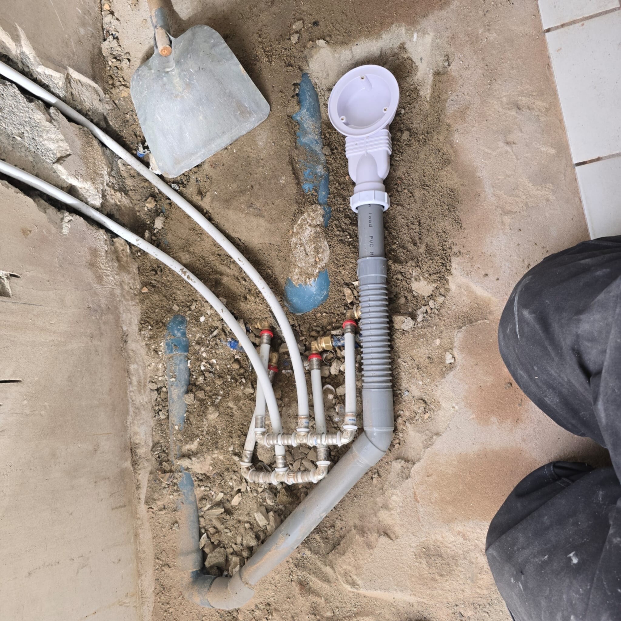 Opengelegde leidingen en rioleringsbuizen in badkamer tijdens renovatie
