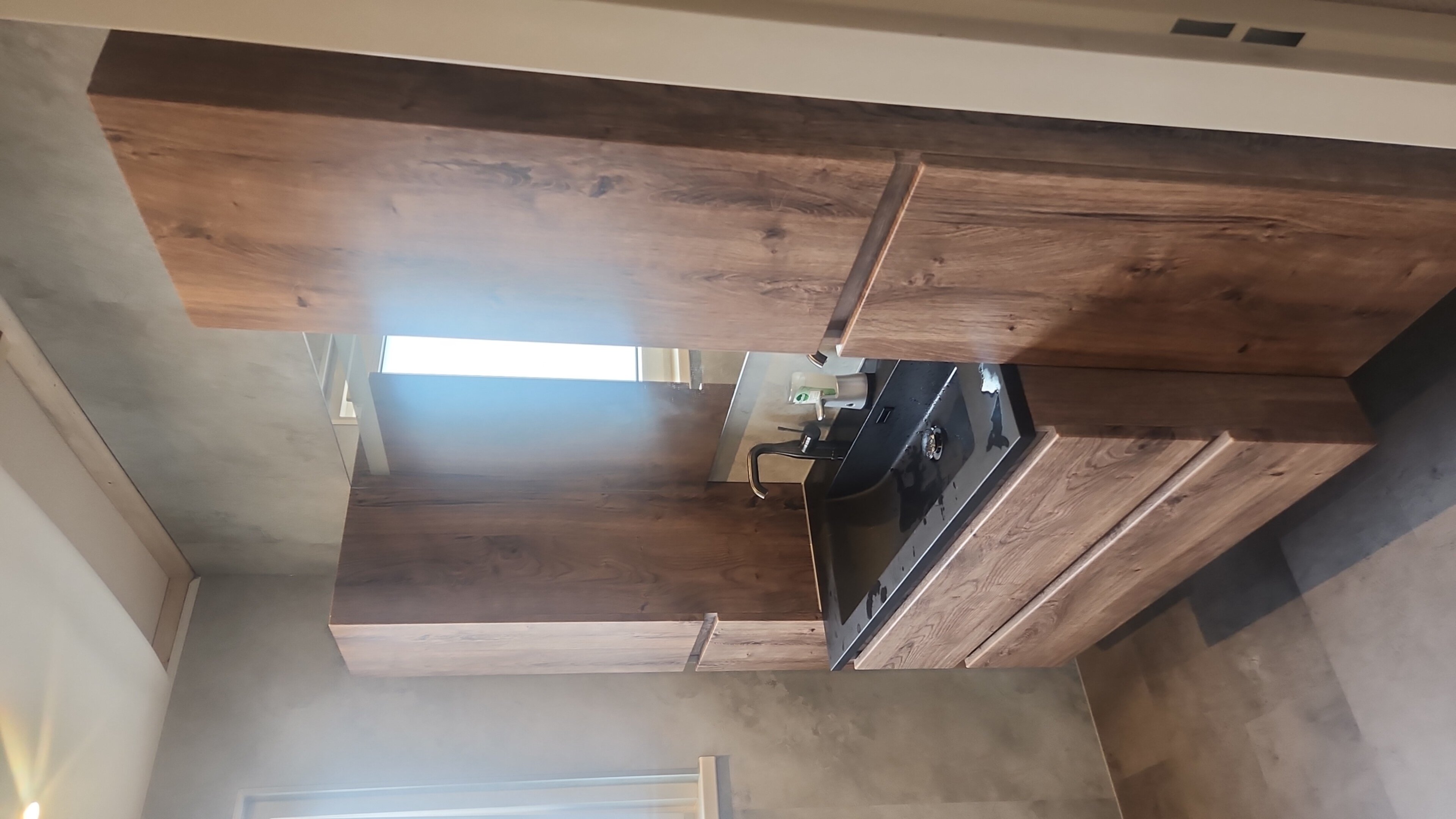 Wastafel met houten meubelen en zwarte kraan in moderne badkamer