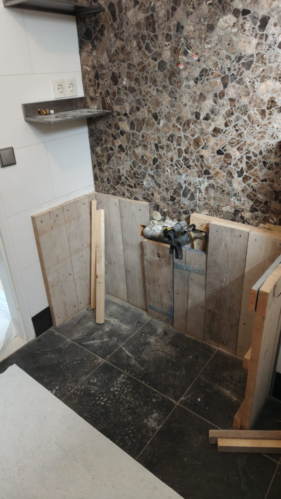 Tijdens badkamer renovatie, houten panelen op de vloer en wand, stenen achterwand
