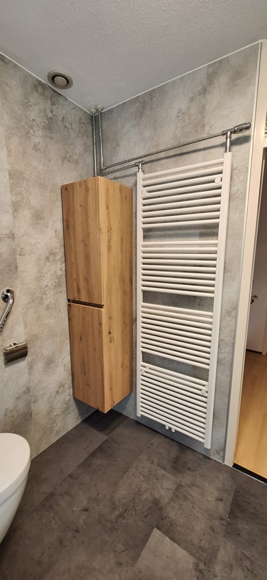 Badkamer met houten kast, witte radiator en betegelde vloer en wanden