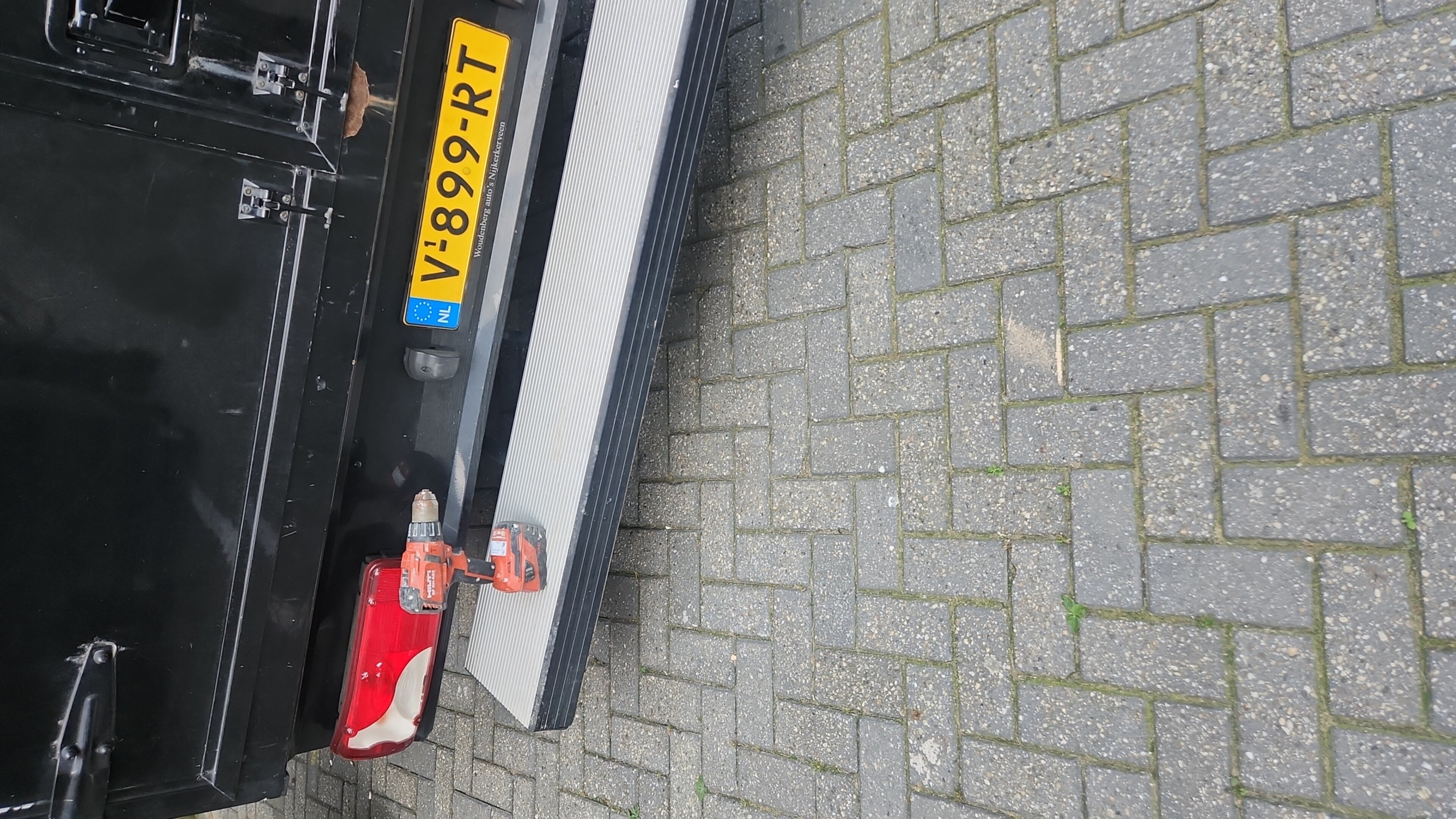 Een close-up van een zwarte auto met een geel kenteken en een rode gereedschap