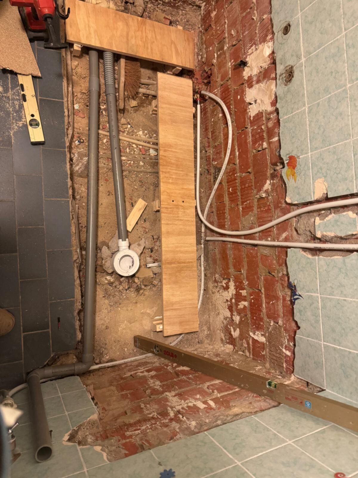 Sloopwerk badkamer met zicht op de rioleringsbuizen en elektriciteitskabels