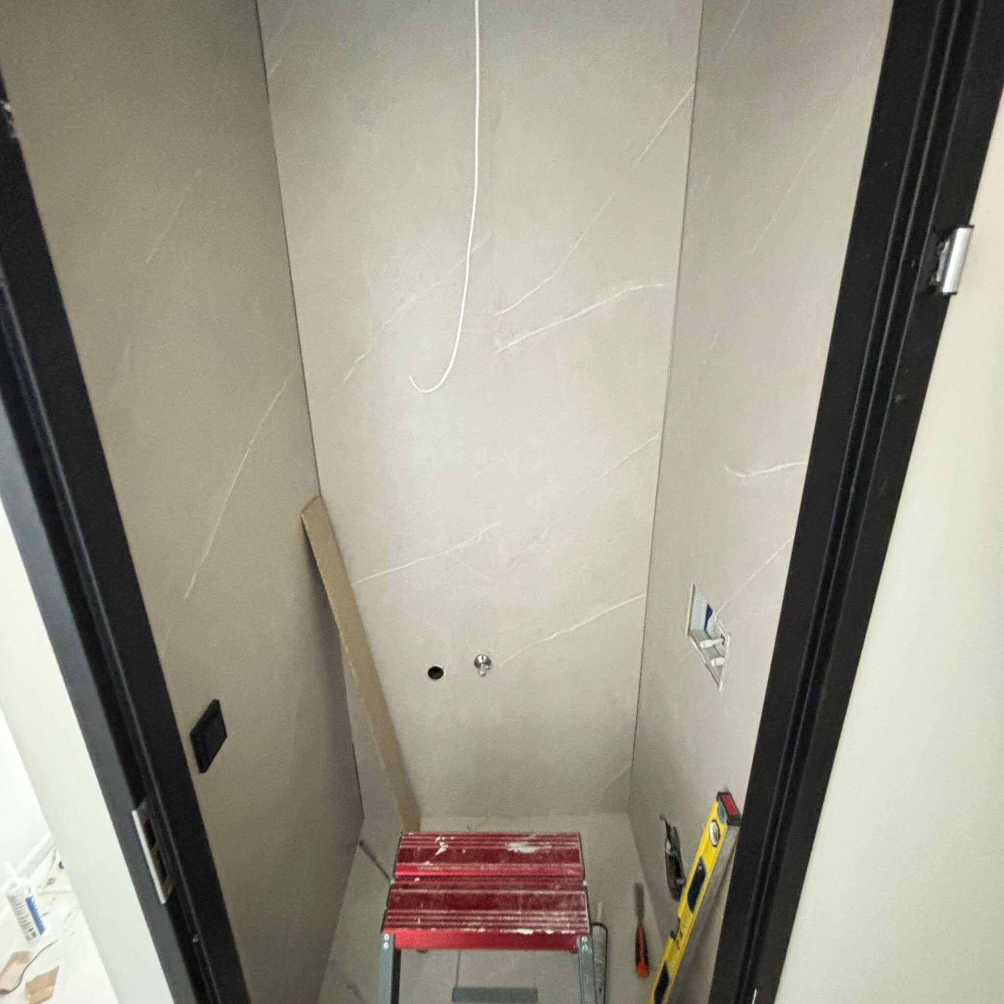 Grote grijze marmeren tegels op de muur tijdens de renovatie van een badkamer