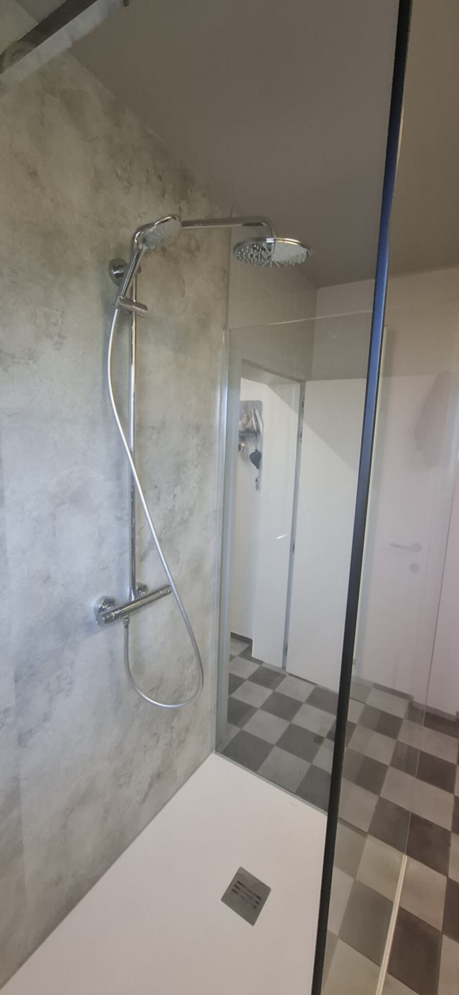 Douchecabine met glazen wand, chroom douchekraan en grijze wandtegels