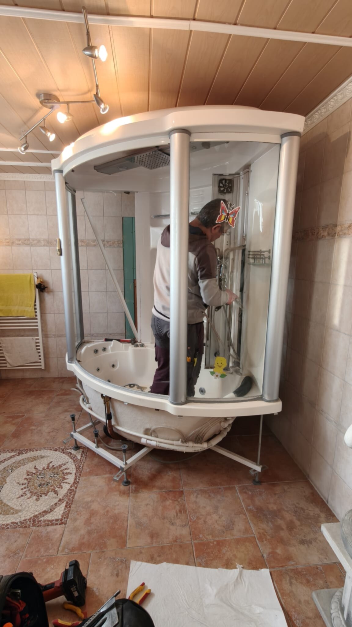 Man installeert witte badkamer douchecabine in betegelde ruimte