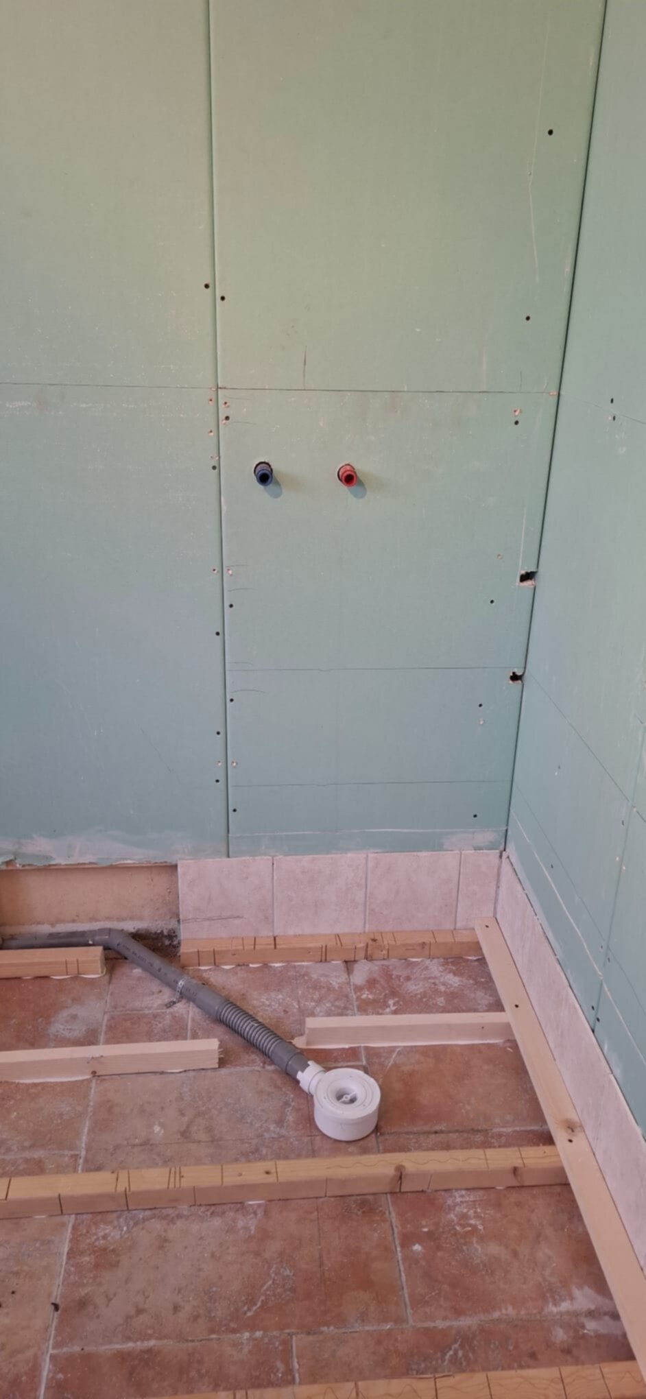Badkamer renovatie in uitvoering met kale wanden en vloer