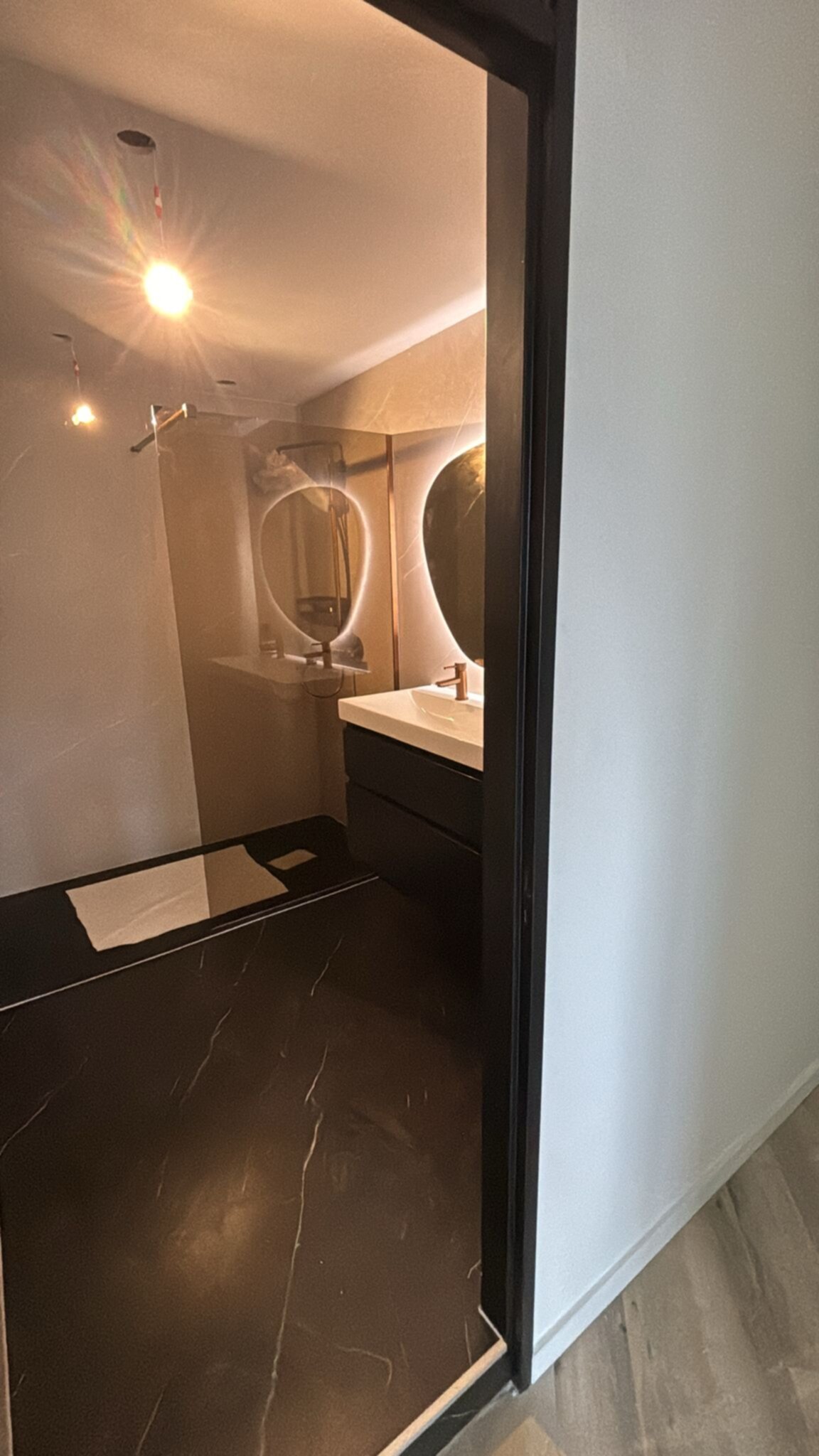 Moderne badkamer met zwarte marmeren vloer en witte wastafel