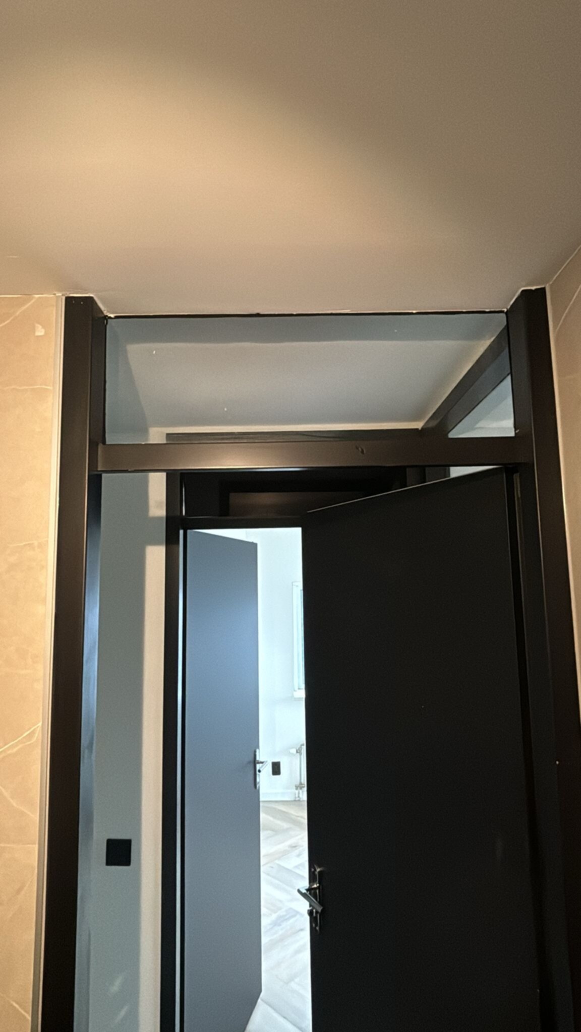 Deur naar badkamer met zwarte deur en glas boven