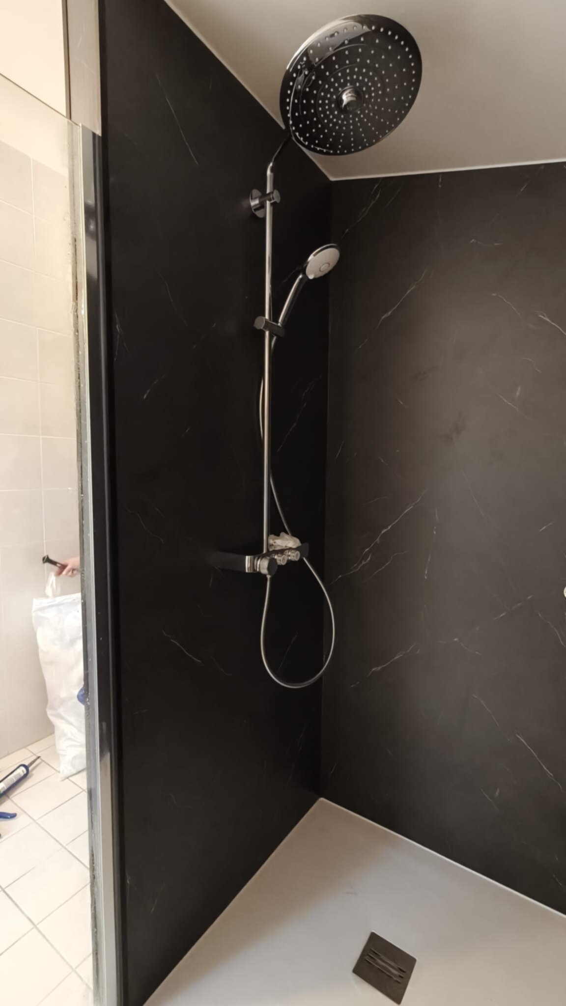 Douche met zwarte marmeren wand en grote ronde douchekop