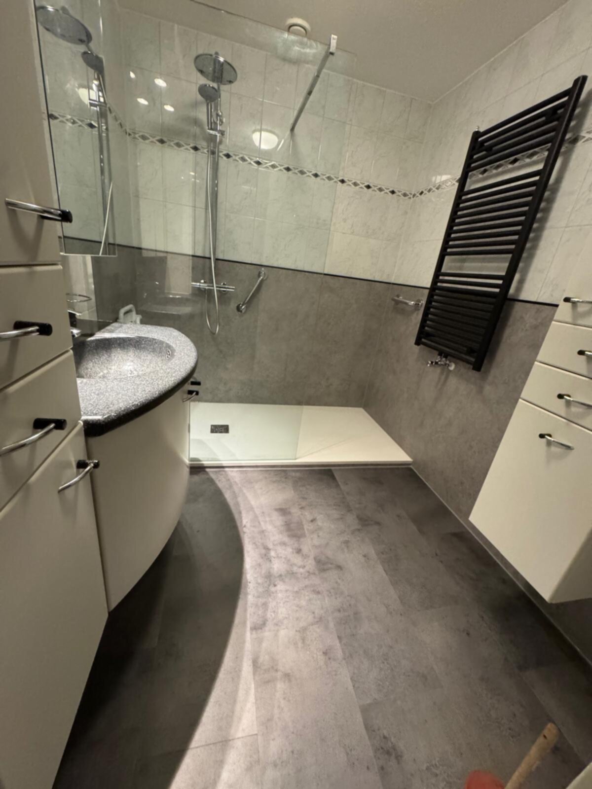 Moderne badkamer met grijze en witte tegels, douche en wastafel