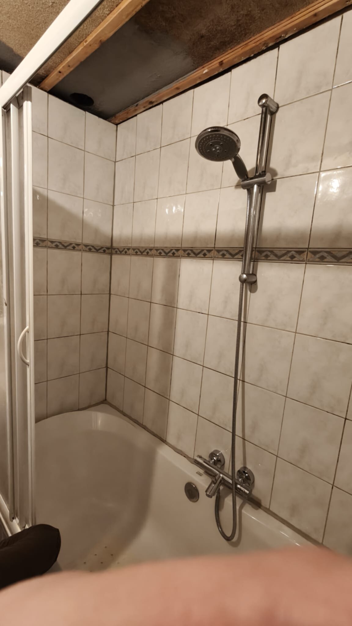 Badkamer met betegelde douche en witte tegelwerk