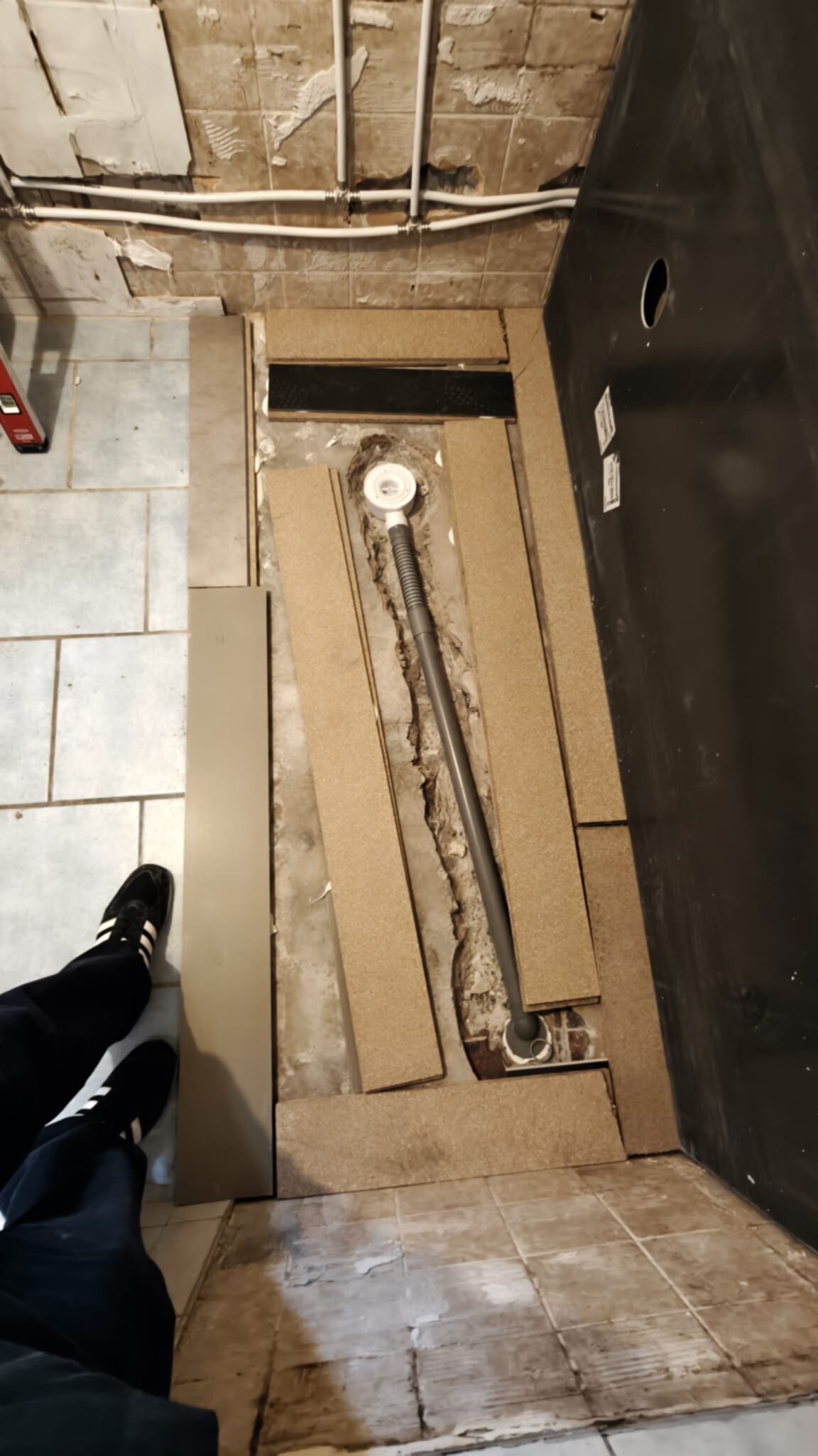 Badkamer renovatie: betegelde vloer met open geslechte vloer voor nieuwe douche