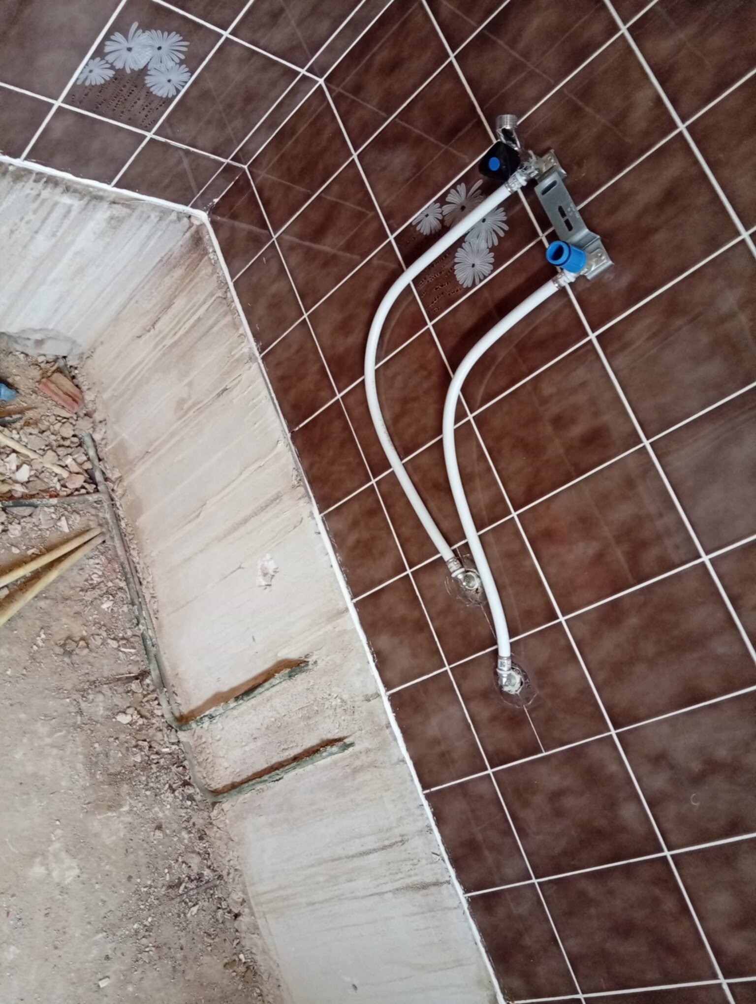 Bestaande betegelde badkamer vloer met twee waterleidingen